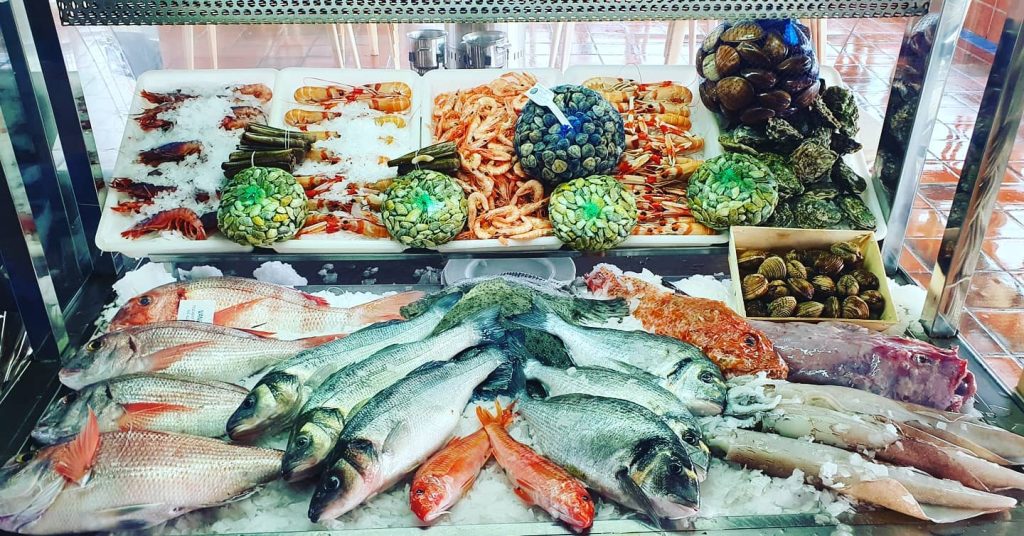 Variedad de pescados y mariscos frescos en el mostrador de Pescados y Mariscos Vanbo en Málaga